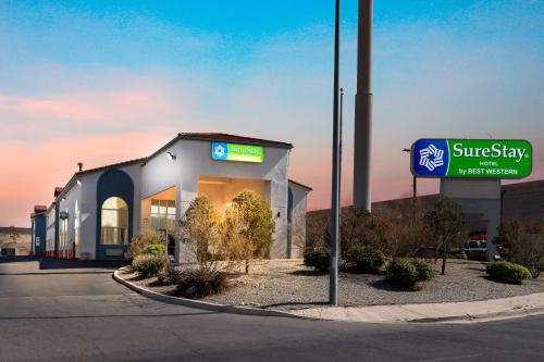 a building with a sign in front of a store at SureStay Hotel by Best Western Albuquerque Midtown in Albuquerque