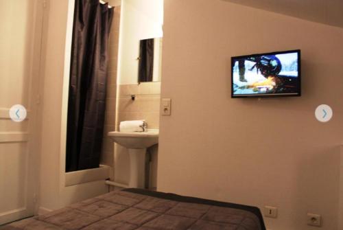 baño con lavabo y TV en la pared en chambre a douai près de gayant expo, Residence Porte d'Arras, en Douai