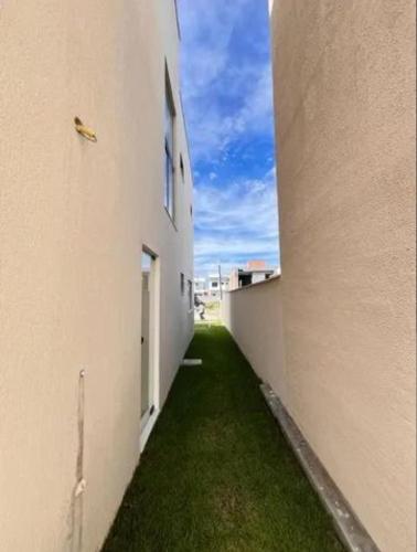 an alley between two buildings with green grass between them at Ribeira House in Salvador