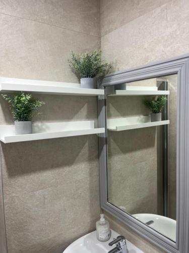 een badkamer met witte planken, een spiegel en een wastafel bij Apartamento exclusivo en Madrid in Madrid