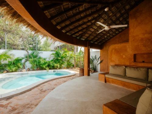 an outdoor patio with a swimming pool and a house at Casona del Sol in Puerto Escondido