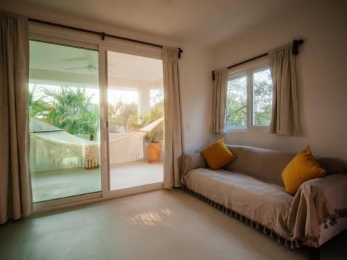 a living room with a couch and a sliding glass door at Casona del Sol in Puerto Escondido