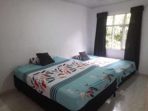 a bedroom with a bed with a colorful bedspread with fish on it at apartamento tercer piso cali in Cali