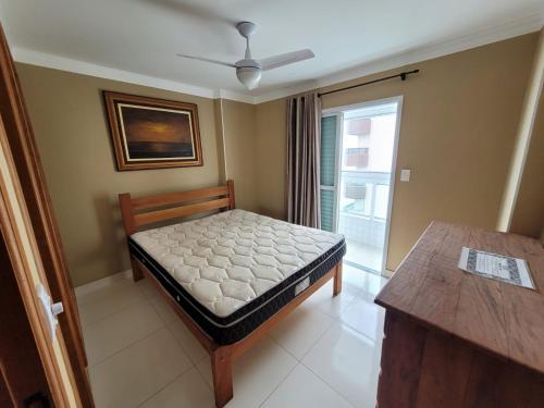 a small bedroom with a bed and a window at Apartamento de frente para o mar, 3 quartos in Solemar