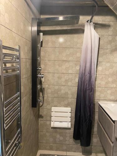 une salle de bain avec une douche avec un rideau de douche dans l'établissement CHEZ MOUNAIM, à Bondy