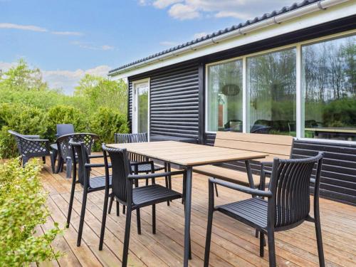 a wooden deck with a wooden table and chairs at 6 person holiday home in Nibe in Nibe