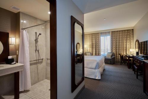 a hotel room with a bed and a bathroom at Sheraton Mesa Hotel at Wrigleyville West in Mesa