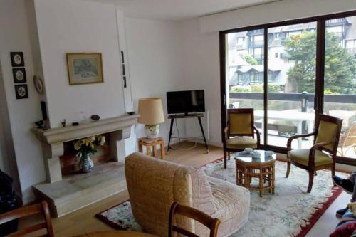 un salon avec une cheminée et une télévision dans l'établissement Spacious apartment in front of the sea, à Deauville