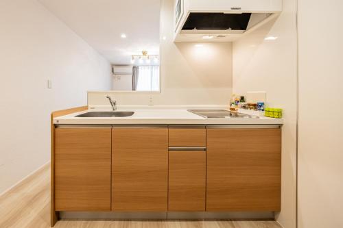 una cocina con armarios de madera y fregadero en 渋谷 広め50m2 2LDK 代々木公園駅徒歩5分 家族におすすめ, en Tokio