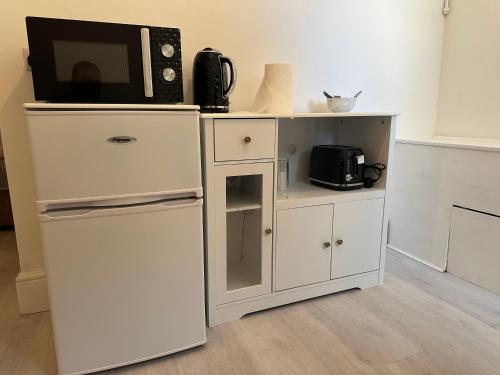 a white cabinet with a microwave and a refrigerator at Independent en-suite bedrooms in Southampton