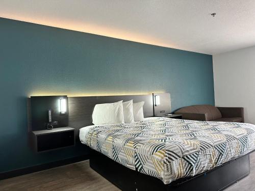 LebecにあるMotel 6-Lebec, CAの青い壁のベッドルーム1室(大型ベッド1台付)