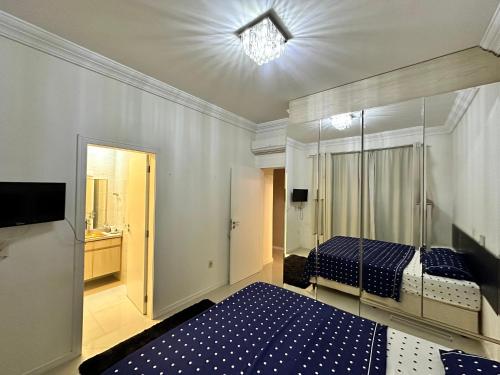 a bedroom with two beds and a television in it at Tropical Palace in Itapema