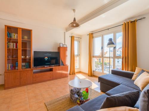 a living room with a couch and a tv at Casa Maresía Penthouse - Pool & Beach in Sardina