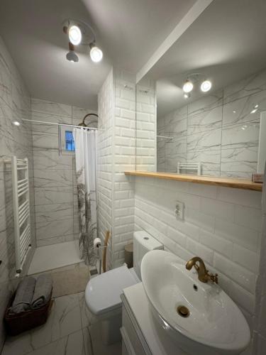bagno bianco con lavandino e servizi igienici di Pinewood Apartment a Miercurea-Ciuc