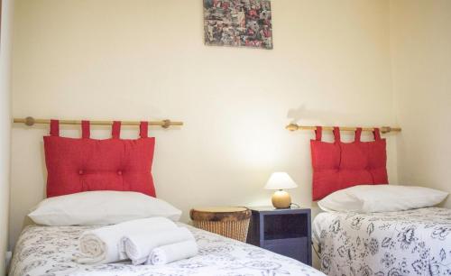2 letti in una camera con cuscini rossi di Cifalino - Full Cozy Apartment with Wi-Fi in Catania a Catania