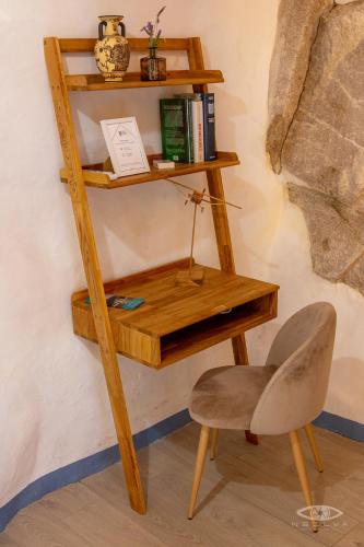 a wooden desk and a chair next to a wall at CelloRico de Sabores - Alojamento Local in Celorico da Beira