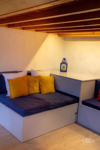 a bench with yellow and blue pillows on it at CelloRico de Sabores - Alojamento Local in Celorico da Beira