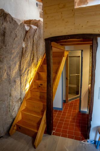 a staircase in a house with a stone wall at CelloRico de Sabores - Alojamento Local in Celorico da Beira
