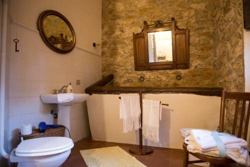 a bathroom with a sink and a toilet and a mirror at Casa di Nonna Maria in Pietraperzia