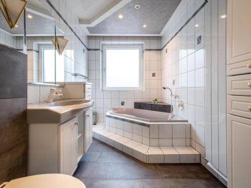 een badkamer met een bad en een wastafel bij Haslau Large in Hopfgarten im Brixental