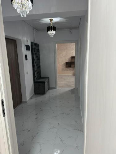 a hallway with a chandelier and a hallway with a hallwayngth at Apartment Lux in Dobroeşti
