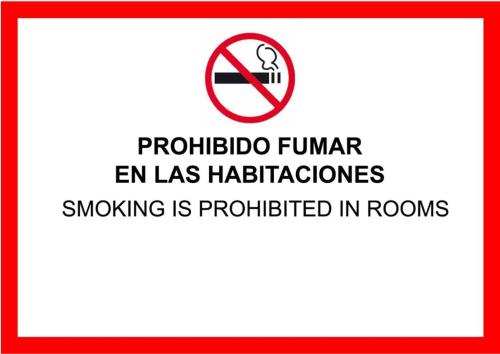 a sign that reads no smoking is prohibited in rooms at SUITES Corrientes in Corrientes