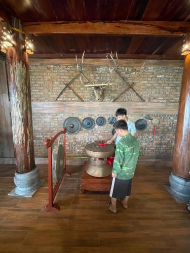 a man standing in front of a pot in a room at Pù Luông Sala Homestay in Hương Bá Thước