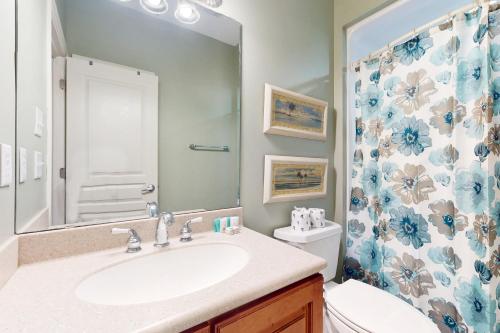 a bathroom with a sink and a toilet and a shower at NTB104 Seas Escape in North Topsail Beach