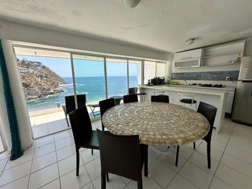 a kitchen and dining room with a table and the ocean at Sirenas in Acapulco