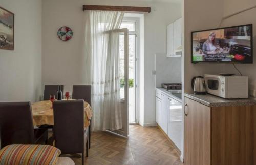 cocina y comedor con mesa y microondas en Apartments by the sea Zuljana, Peljesac - 4577, en Žuljana