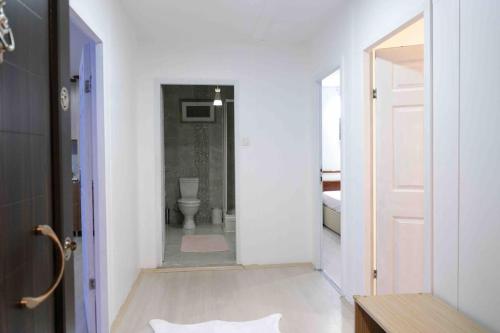 La salle de bains blanche est pourvue de toilettes et d'une porte. dans l'établissement İZNİK Lake House, à İznik
