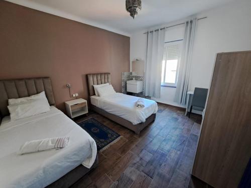 a hotel room with two beds and a window at El Muniria in Tangier
