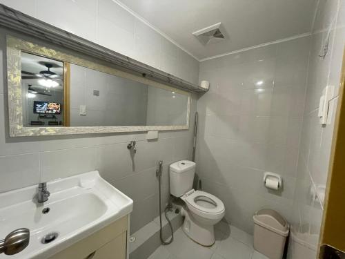 a bathroom with a sink and a toilet and a mirror at Szedeli Condo unit rental 3 in Iloilo City