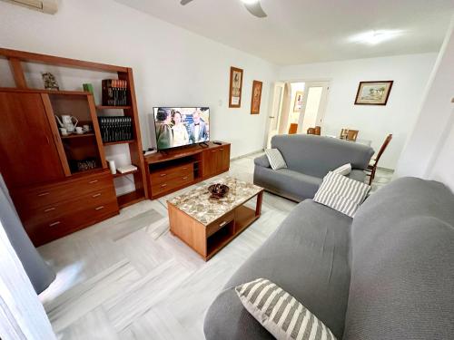 sala de estar con sofá y mesa en Málaga Capital - Zona Oeste: Parking-Wifi-Piscina en Málaga