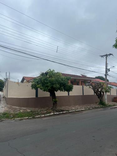 a street with two trees on the side of a wall at Hotel Ceres 24 - QUARTO COM VENTILADOR in Cuiabá