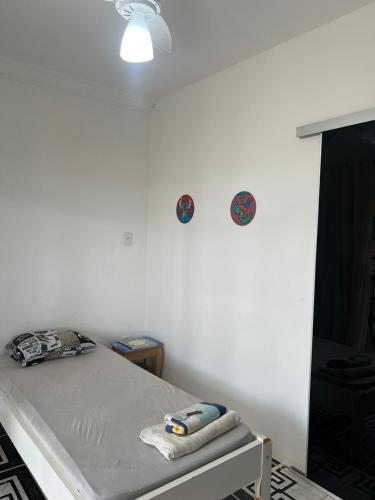 a white room with a bed and two plates on the wall at Hotel Ceres 24 - QUARTO COM VENTILADOR in Cuiabá