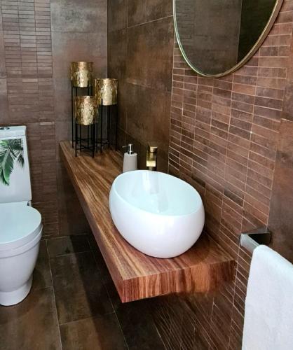 a bathroom with a white sink and a toilet at Magnolia Residence - central to explore the island in Ribeira Grande