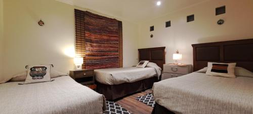 a hotel room with two beds and a window at Chill Atacama Harickuntur in San Pedro de Atacama