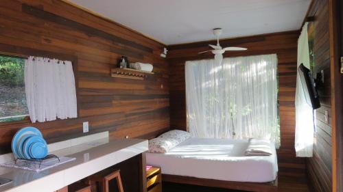 um quarto com uma cama, um lavatório e uma janela em Cabanas sítio Ancestral em Morretes