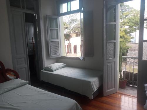 a room with two beds and a window at Pousada Gameleira in Diamantina