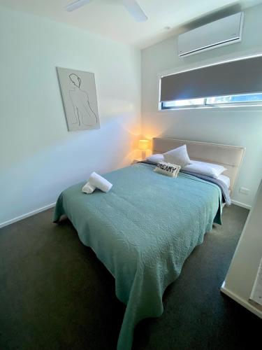 a bedroom with a bed with a green comforter at Bundalong Villas in Bundalong