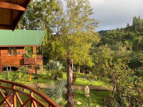 a house with a deck and a yard with a yard at Oasis de Tendéa - Bali à Farino in Farino