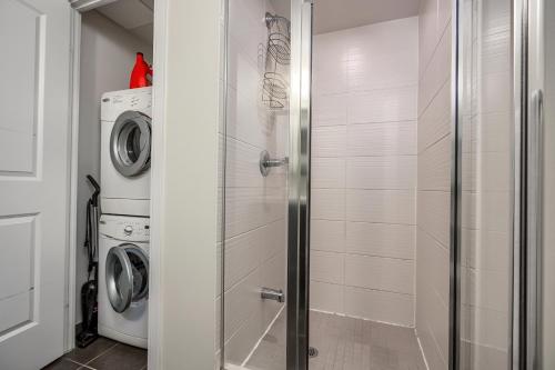 a bathroom with a washer and dryer next to a washing machine at Condo in the heart of Downtown Toronto! in Toronto