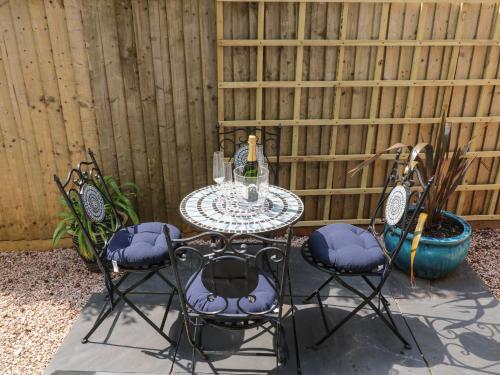 a table and four chairs in front of a fence at Little Rondeval in Totnes