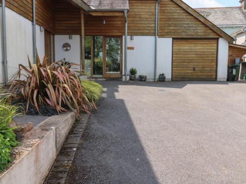 a driveway leading to a building with a garage at Little Rondeval in Totnes
