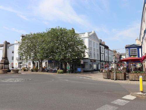 an empty city street with buildings and a tree at Little Rondeval in Totnes