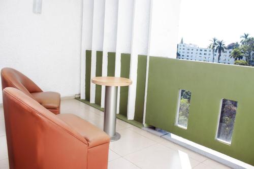 a chair and a table in a room with a window at Hotel Borda Cuernavaca in Cuernavaca
