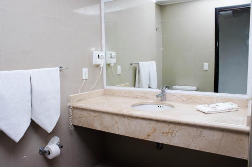 a bathroom with a sink and a mirror and towels at Hotel Borda Cuernavaca in Cuernavaca