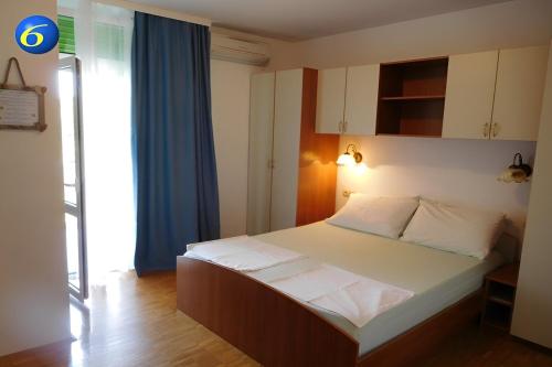 una camera da letto con un letto grande con lenzuola bianche di Rooms by the sea Supetarska Draga - Donja, Rab - 23068 a Rab