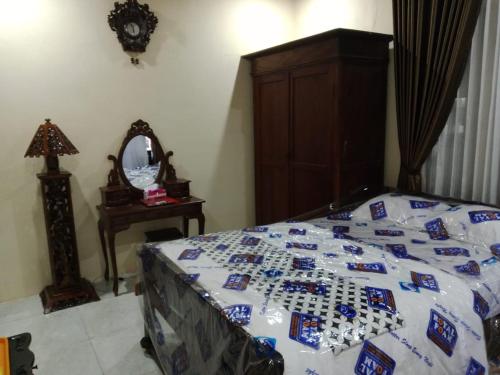 a bed with a quilt on it with a mirror at Mbah Oden Homestay Borobudur in Mendut